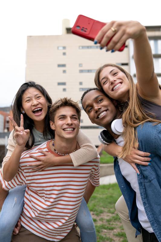 Multicultural joyful group of friends taking a selfie smiling .Diverse young people having fun and taking pictures outside.