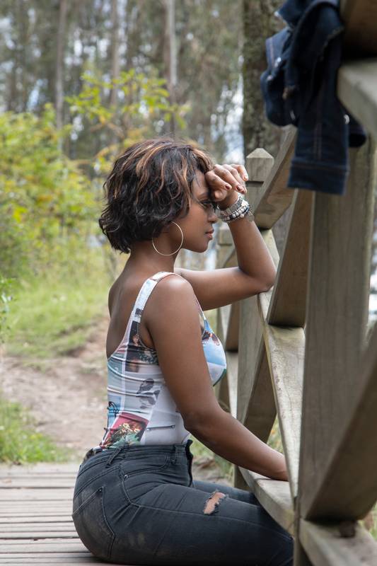 black woman with short hair, wearing makeup, accessories and casual clothes