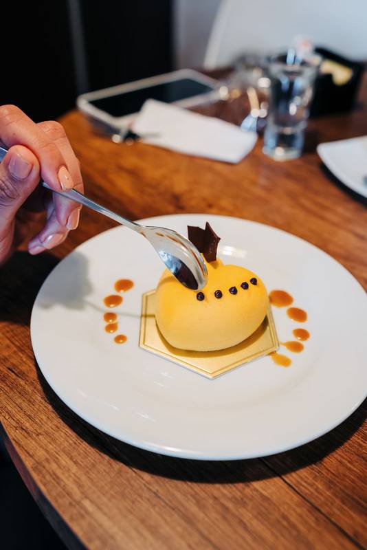 eating a heart-shaped cake decorated with yellow icing, restaurant dining