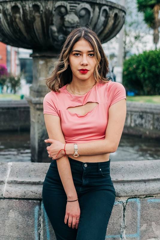 latin woman with her long wavy blonde hair, looking at the camera