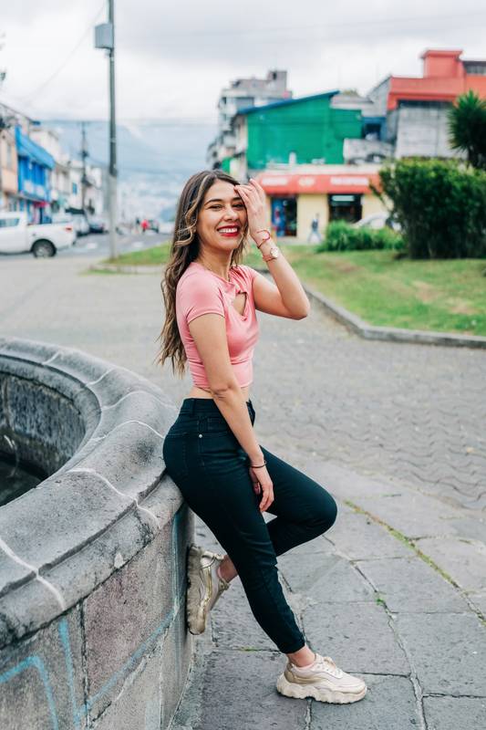woman standing leaning against stone wall