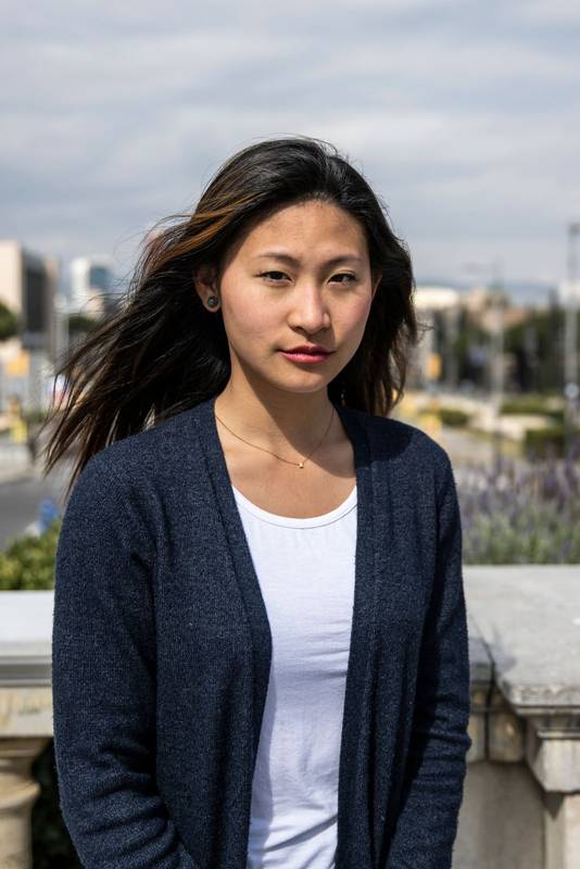 Young beautiful confident woman looking at camera standing outdoors. Determined lady staring at camera in a casual style in the street.