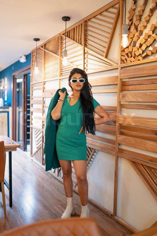 posing standing beautiful young latin woman with long black hair posing with a blazer