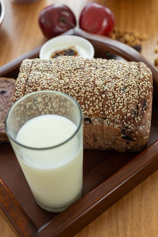wholesome meal featuring a glass of fresh milk, a slice of soft bread, and a crisp apple, offering a balanced and refreshing snack