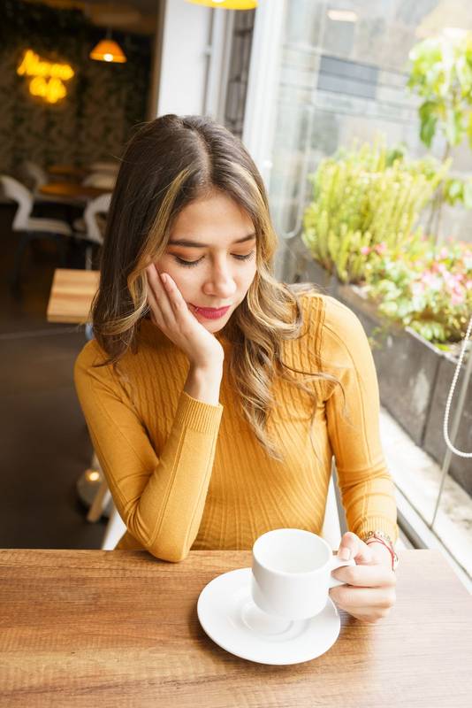 sitting at a table a beautiful, young, latin woman with long blonde hair