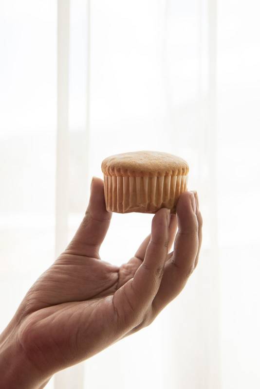 showing a muffin, white studio background, skin texture and baked food