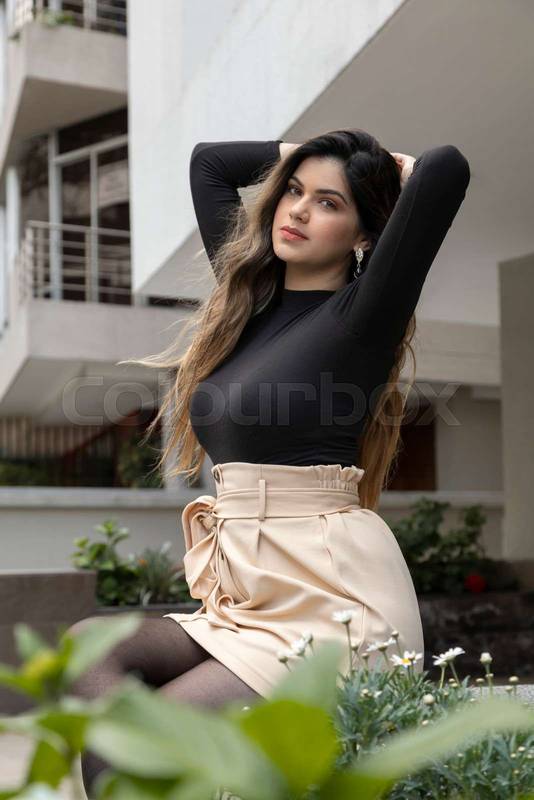 body of a young, Latin girl with long blond hair wearing makeup that is with raised arms