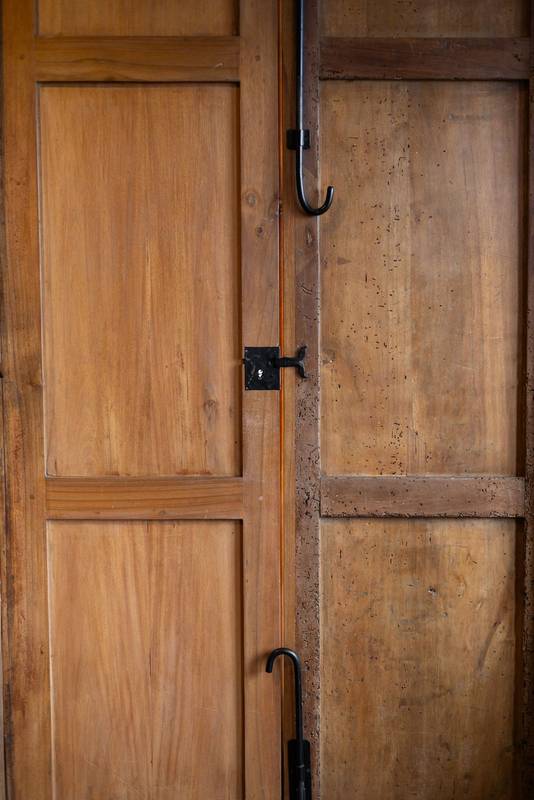 Close-up of an antique wooden door with a worn surface and classic metal handle