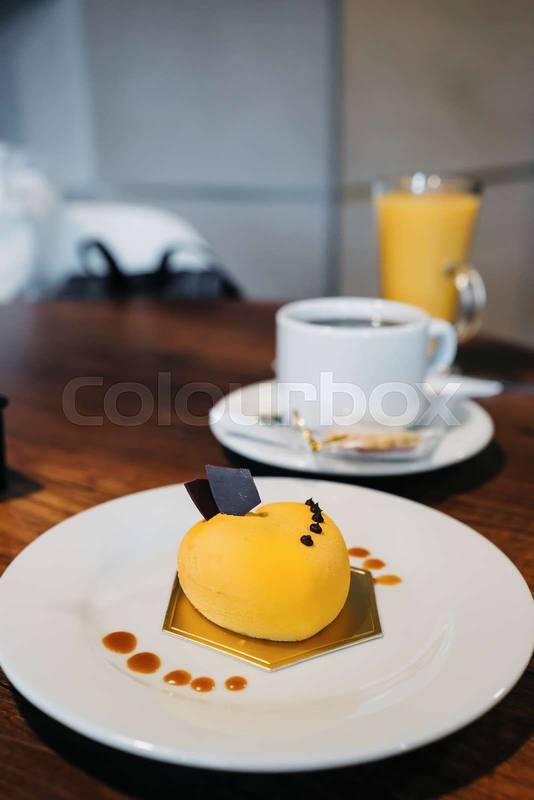 plate of food and drinks, ahead a gourmet decorated cake, a cup of coffee