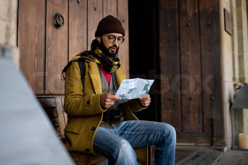 young tourist woman exploring city map in the street. holidays, tourism and travel concept