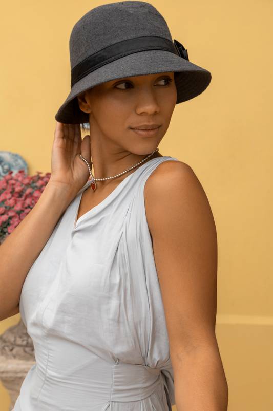 young female model wearing a hat and white casual bodysuit, fashion