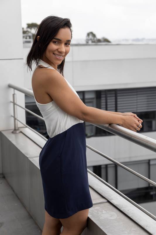 young latin woman with short straight hair standing by a window on a sunny day