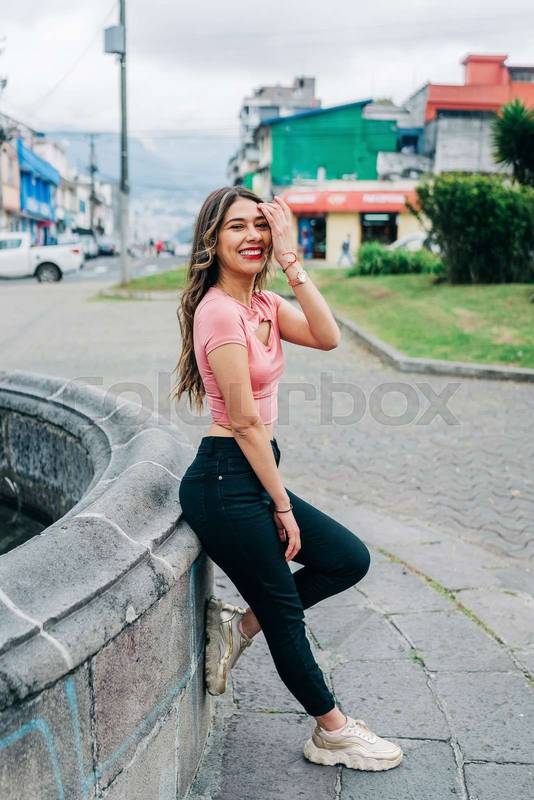 woman standing leaning against stone wall