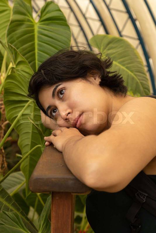 resting on a wood, young latin woman with short black hair, details of the face