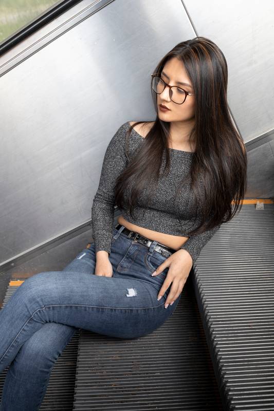model  is resting sitting on some stairs