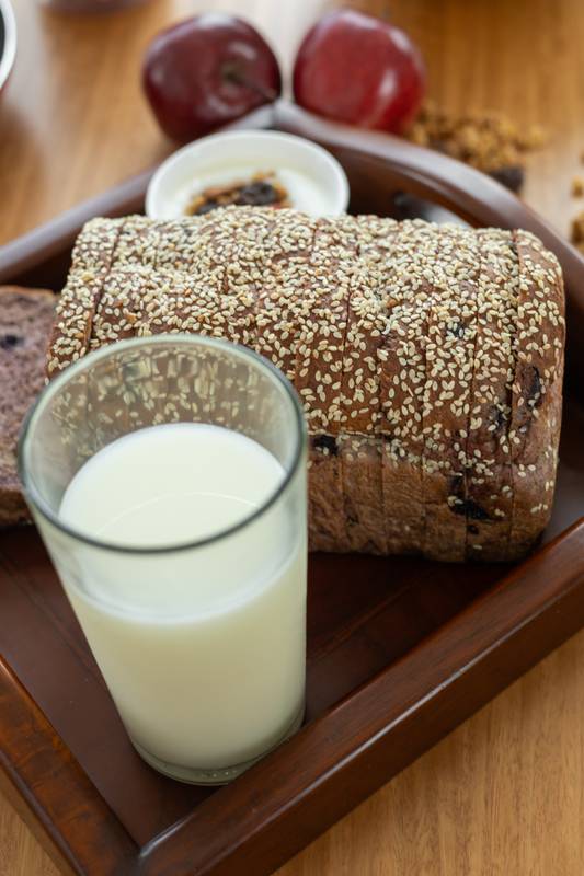 wholesome meal featuring a glass of fresh milk, a slice of soft bread, and a crisp apple, offering a balanced and refreshing snack