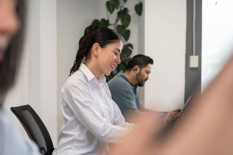 man and woman smile as they exchange ideas and work