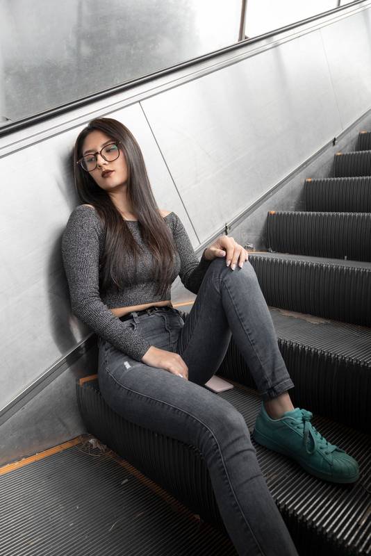 emale model with straight black hair wearing glasses