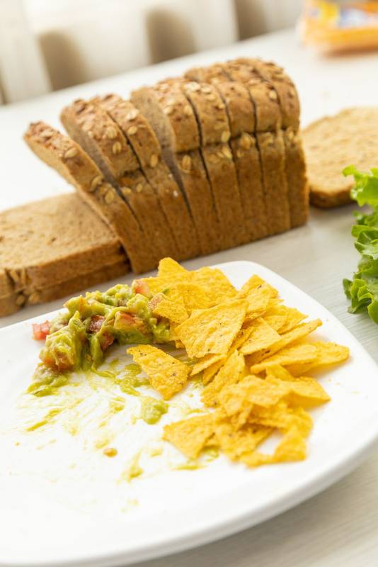 bread next to a lettuce and a plate with nachos