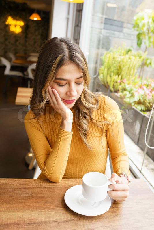 sitting at a table a beautiful, young, latin woman with long blonde hair
