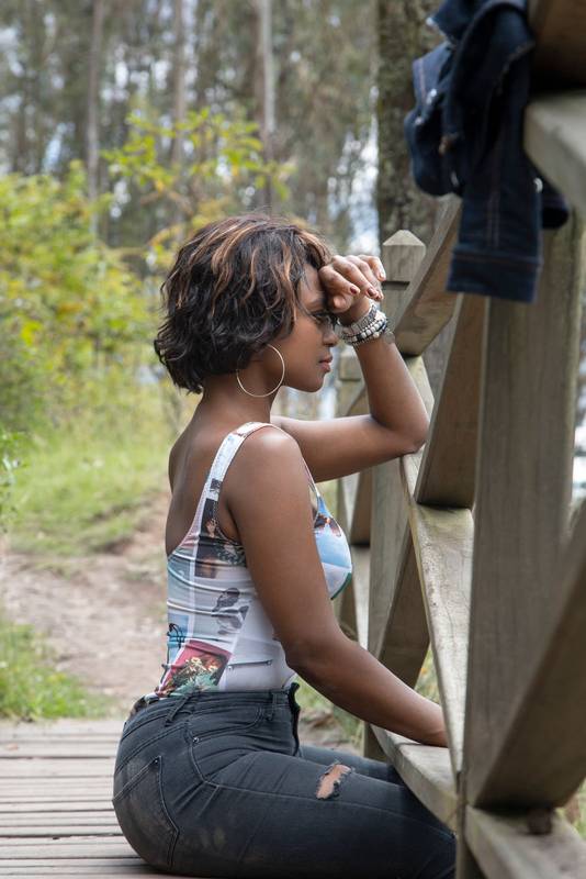 black woman with short hair, wearing makeup, accessories and casual clothes