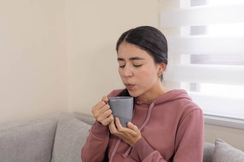 holding a warm cup of coffee and enjoying a calm morning moment at home.