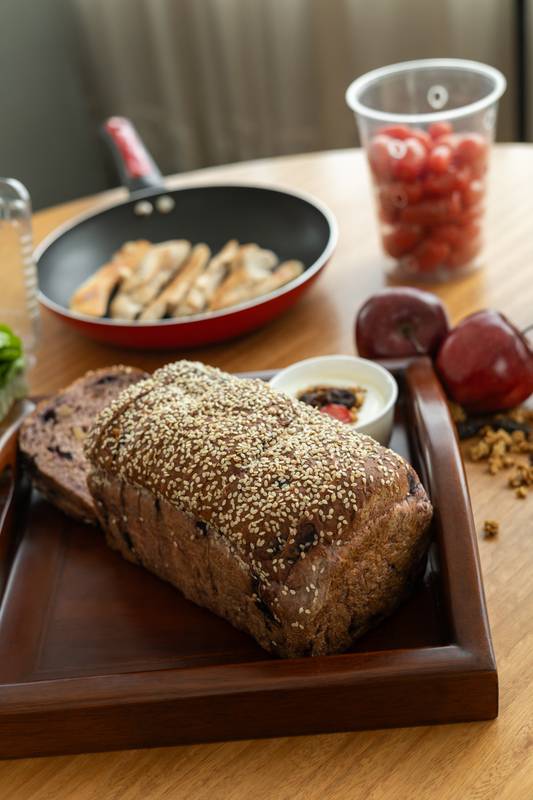 plate featuring a vibrant mix of fresh fruit and crunchy cereal, complemented by a slice of warm bread.