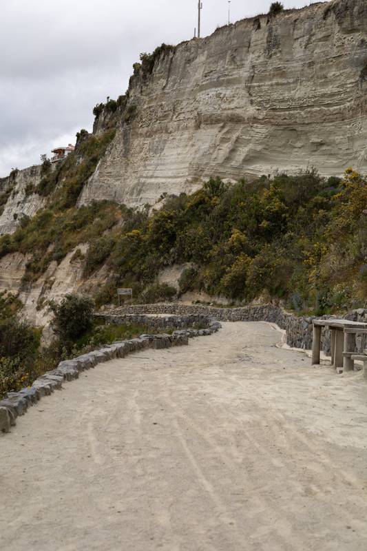 rustic dirt path winds through green mountains, serving as a vital route