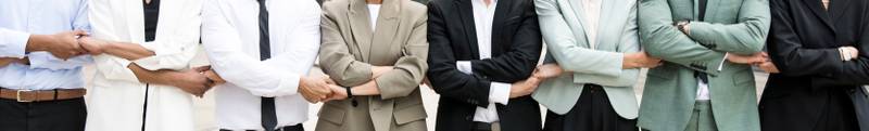 Panoramic close up of an executive team standing in a line holding hands. Businesspeople bonding together standing. Teamwork concept