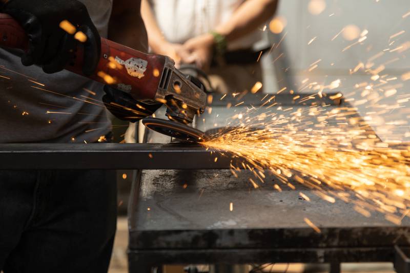 using a metal polishing tool, sparks from the maquilas, machine manual work