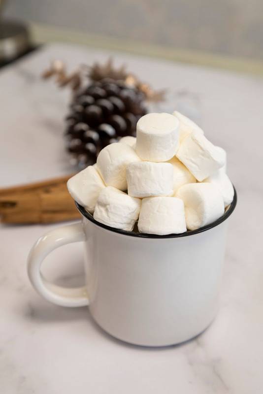 cup with a hot drink and marshmallows decorating a table, food and drink on holidays