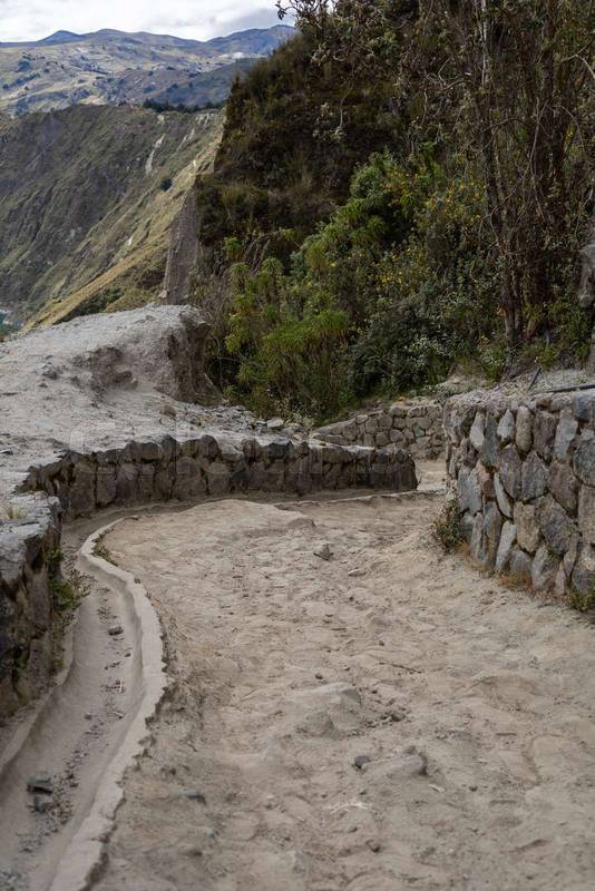dirt and stone path curves around a towering mountain, inviting explorers to an unforgettable journey