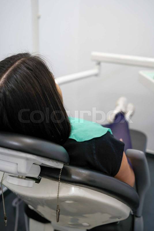 patient sitting in the reclining chair of a dental office