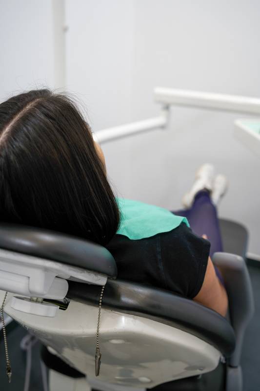 patient sitting in the reclining chair of a dental office