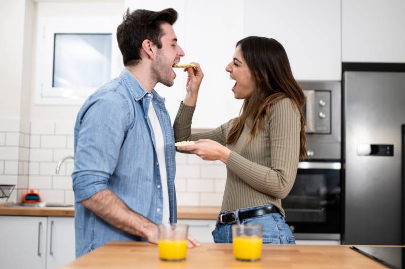 Happy young couple preparing healthy food on the kitchen. Romantic and funny breakfast