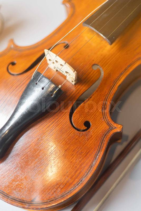 violin placed on a wooden table under soft warm light, showing artistic