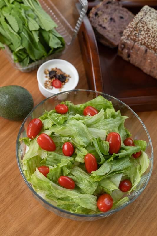 refreshing salad of crisp lettuce and ripe tomatoes served in a large bowl