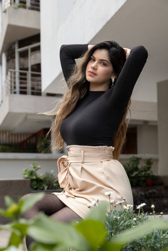 body of a young, Latin girl with long blond hair wearing makeup that is with raised arms